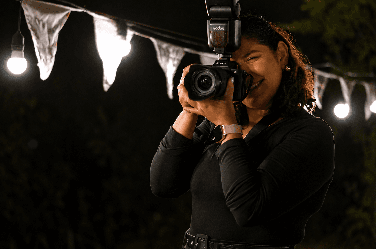 Fotógrafa del equipo FAU.MONS retratando con cámara y flash en una sesión nocturna al aire libre